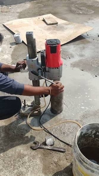 Worker drilling into concrete with power tool — concrete drilling Palakkad