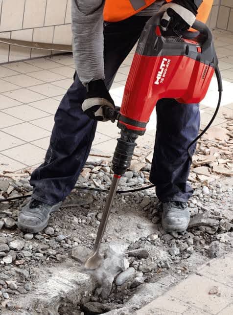 Worker using demolition hammer breaking concrete — demolition Palakkad